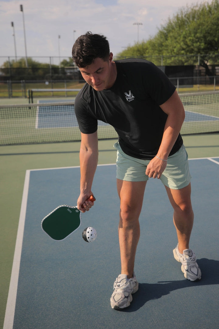 Person playing pickleball on an outdoor court.
