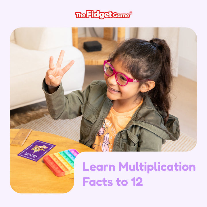 Child with glasses showing a peace sign, sitting at a table with educational materials and the fidget game branding.