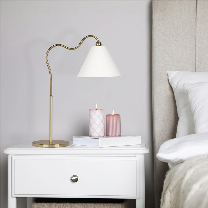 Ornate Brass Ring Base Curved Table Lamp with Triangle White Drum Shade with Background.