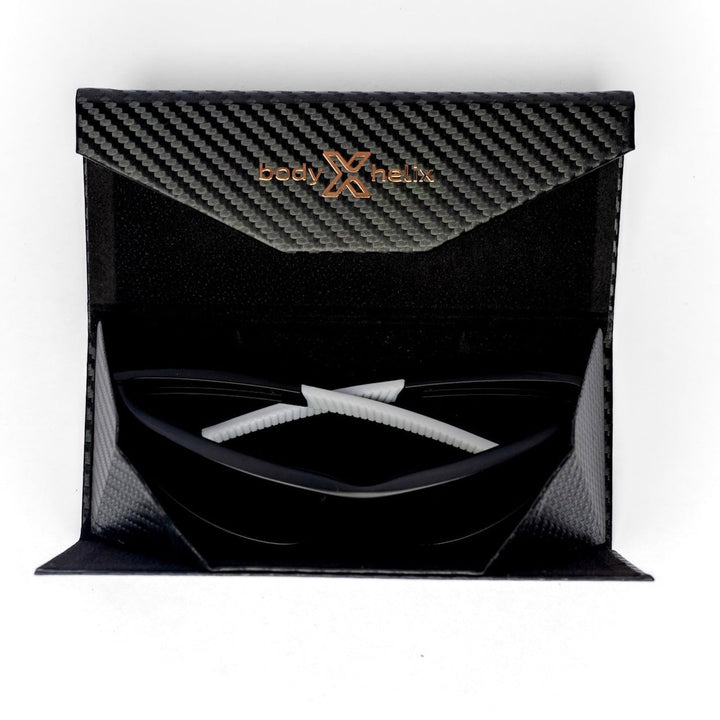 Black carbon fiber packaging with body helix branding containing a white product on a white background.