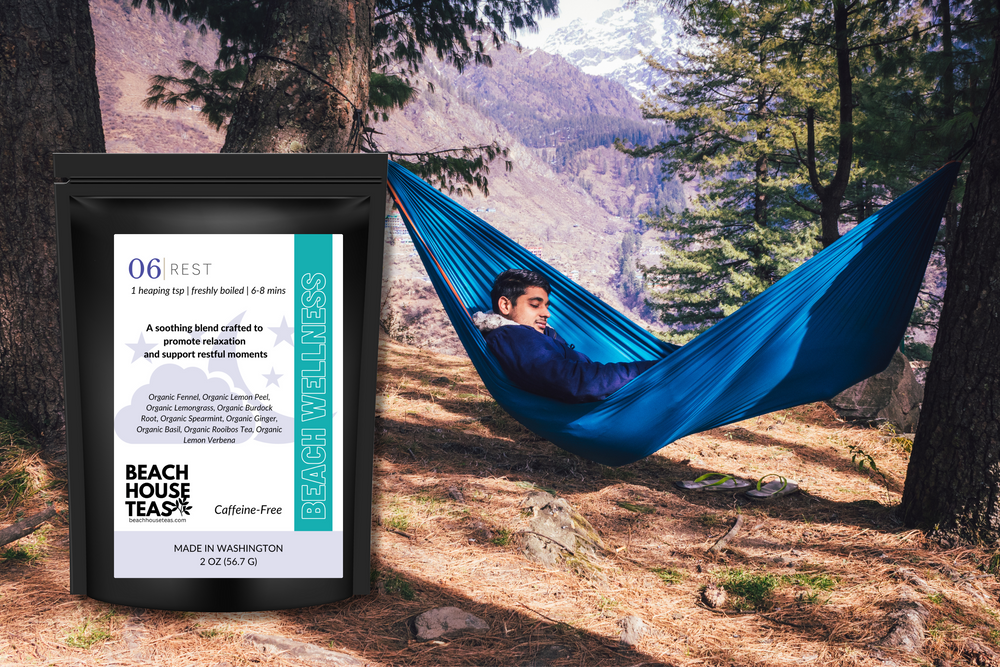 Person relaxing in a blue hammock with a Beach House Teas package in the foreground, set against a scenic forest background.