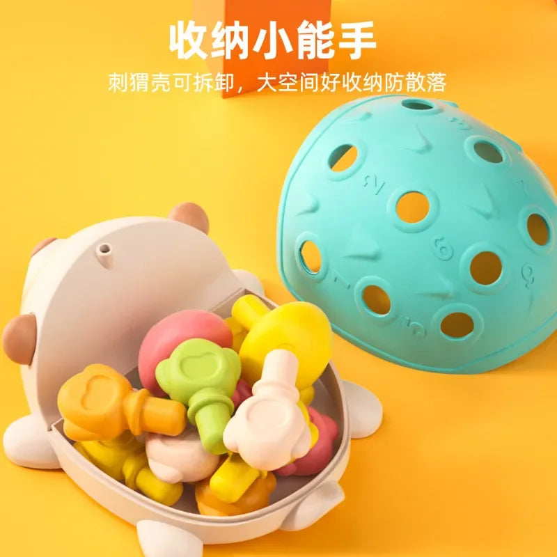 Colorful baby teething toys in a holder with a detachable ball on a yellow background.