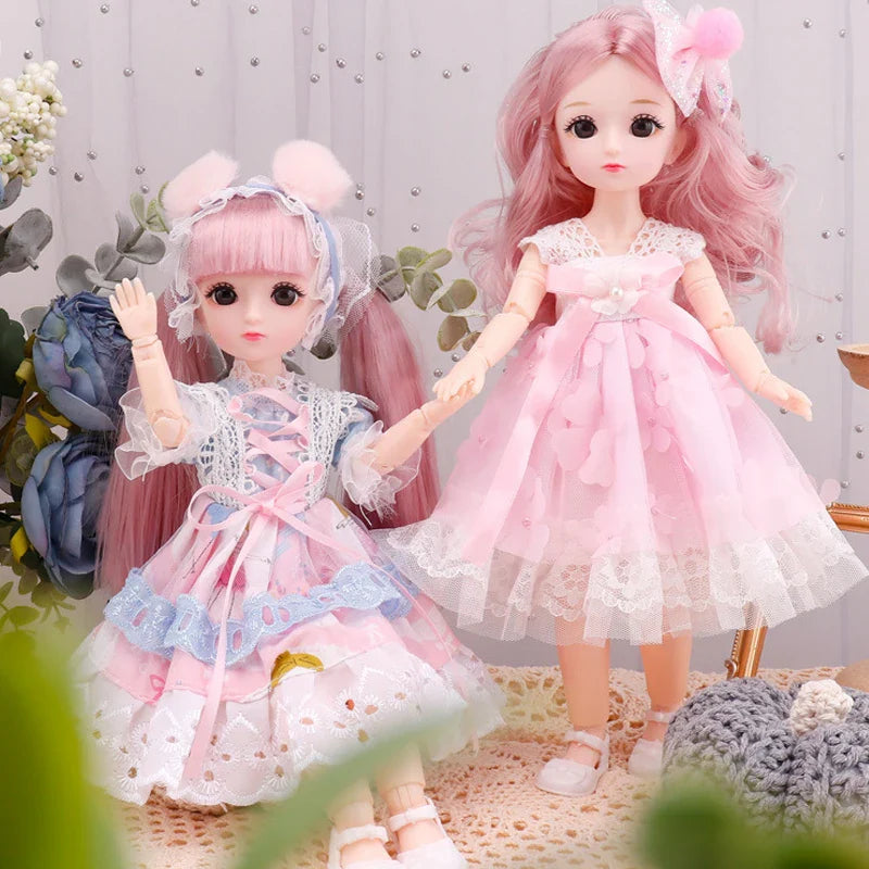 Two dolls with pink hair and dresses in a decorative setting with flowers and soft textures.