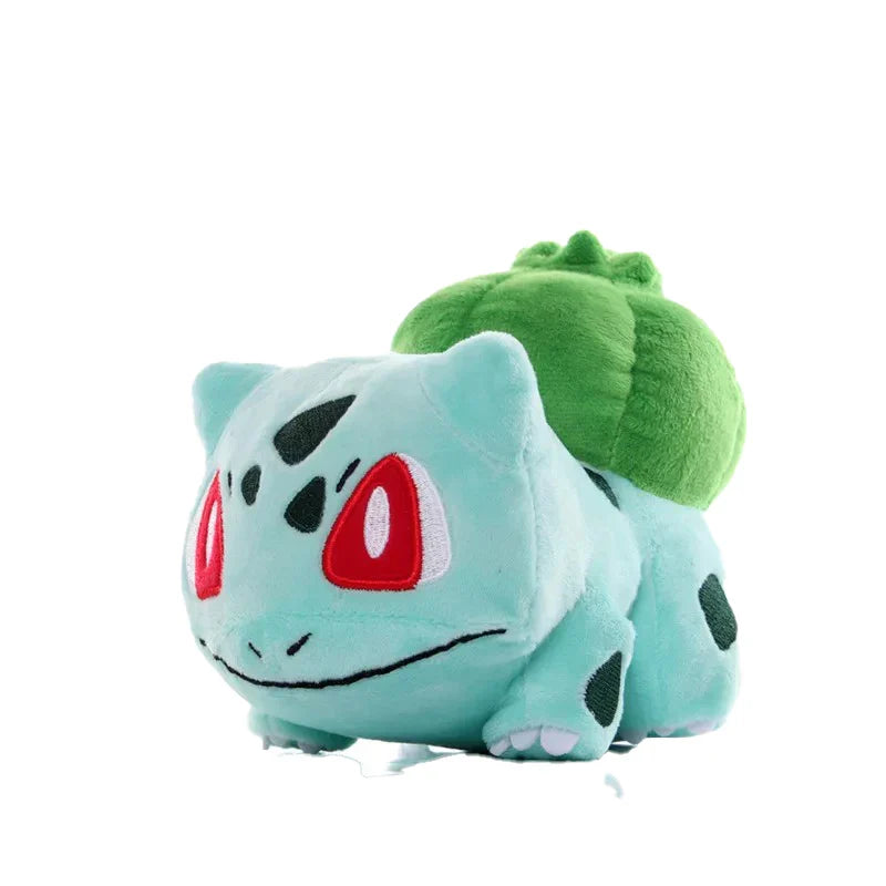 Plush toy of a green and blue creature with red eyes on a white background.