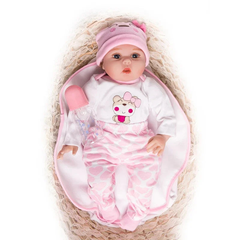 Baby doll in a pink outfit with a bear design, lying in a woven basket on a white background.