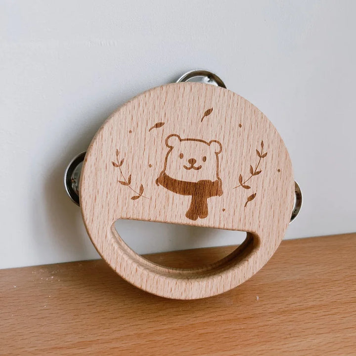 Wooden teething ring with bear design on a wooden surface.