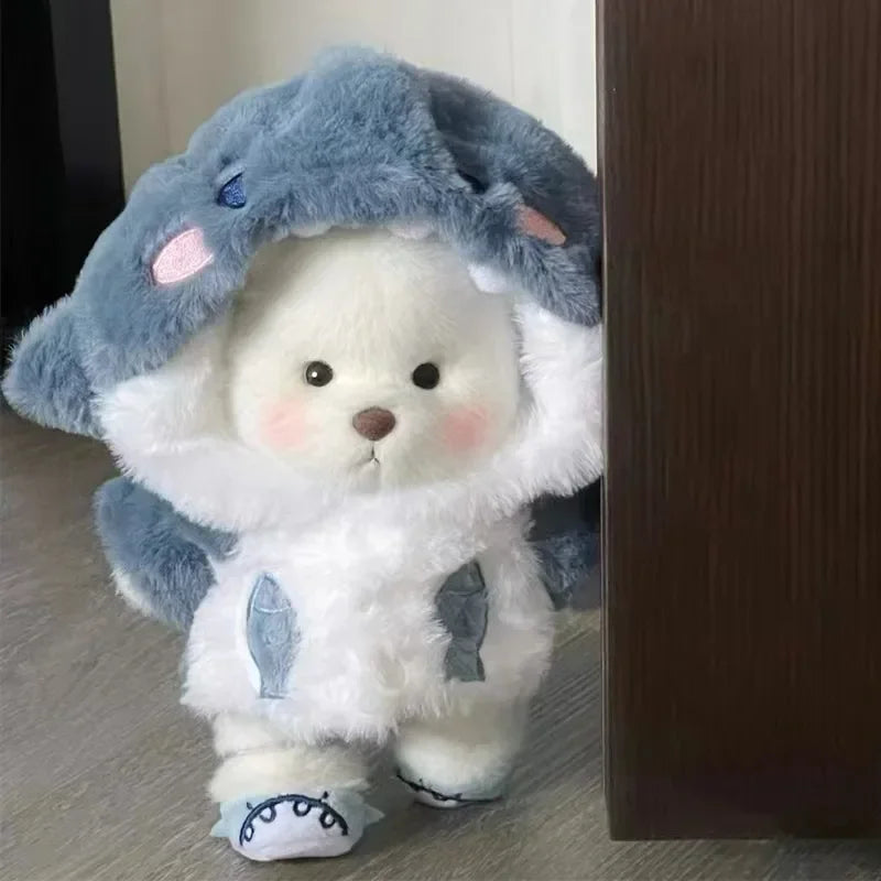Plush toy with a blue hood and white body on a wooden floor.