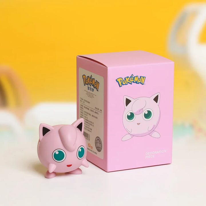 Pink Jigglypuff figurine next to its packaging with a yellow background.
