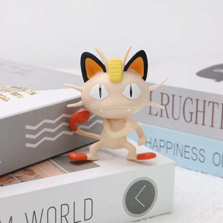 Small figurine of a cat-like creature with large eyes on top of a box.