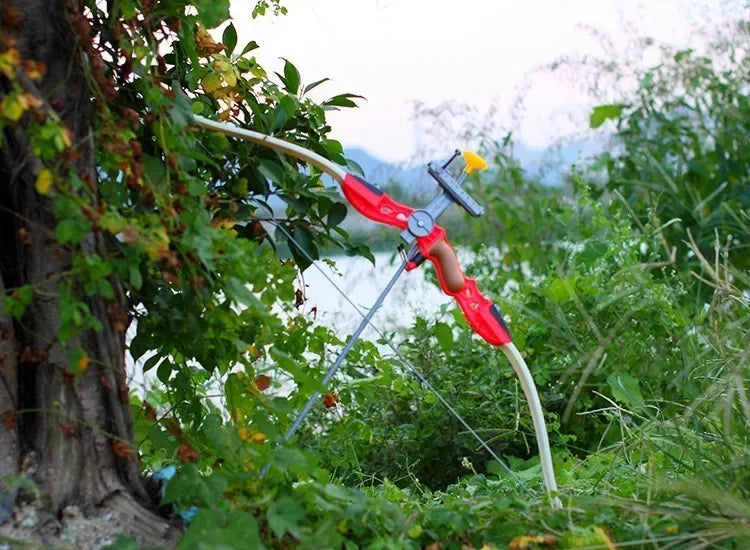 Red pruning shear cutting through green leaves with a blurred natural background.