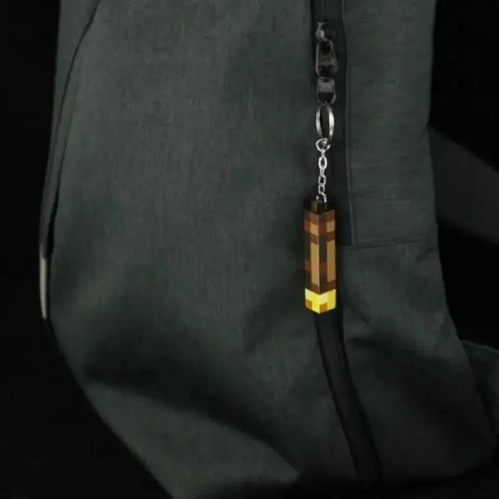 Keychain with a metal chain attached to a dark jacket pocket.