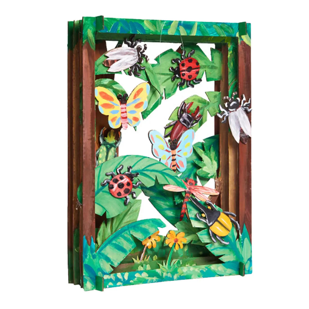 Shadow box with colorful illustrations of insects and foliage on a white background.