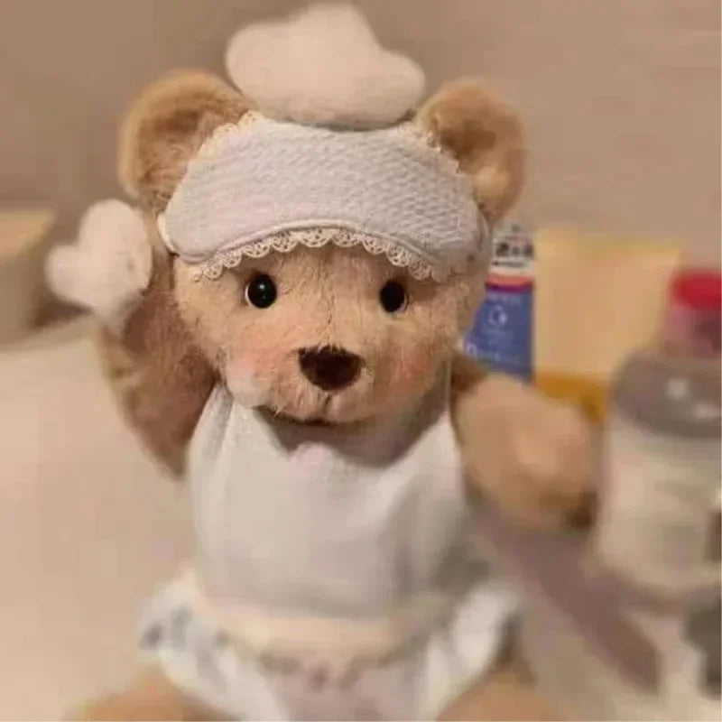 Teddy bear wearing a nightcap and pajamas with a blurred background.