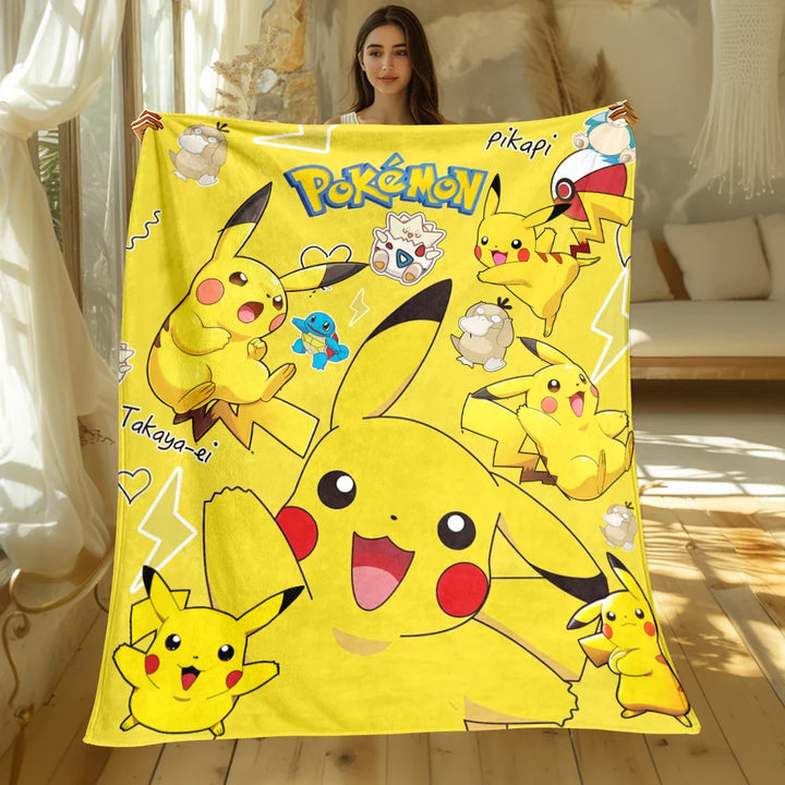 Person holding a Pokémon Pikachu-themed blanket in a room.