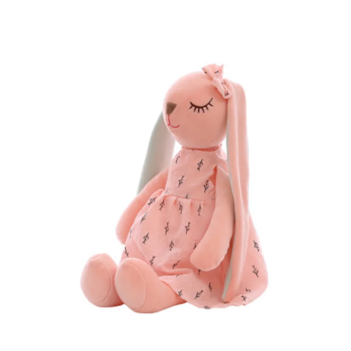 Pink plush toy with a dress on a white background.