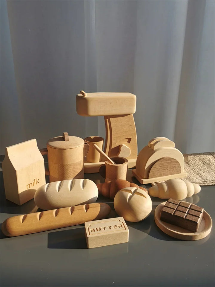 Collection of wooden food items and kitchenware on a reflective surface with a neutral background.