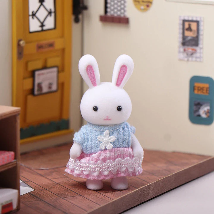 Plush toy rabbit in a blue sweater and pink skirt on a wooden surface with a colorful background.