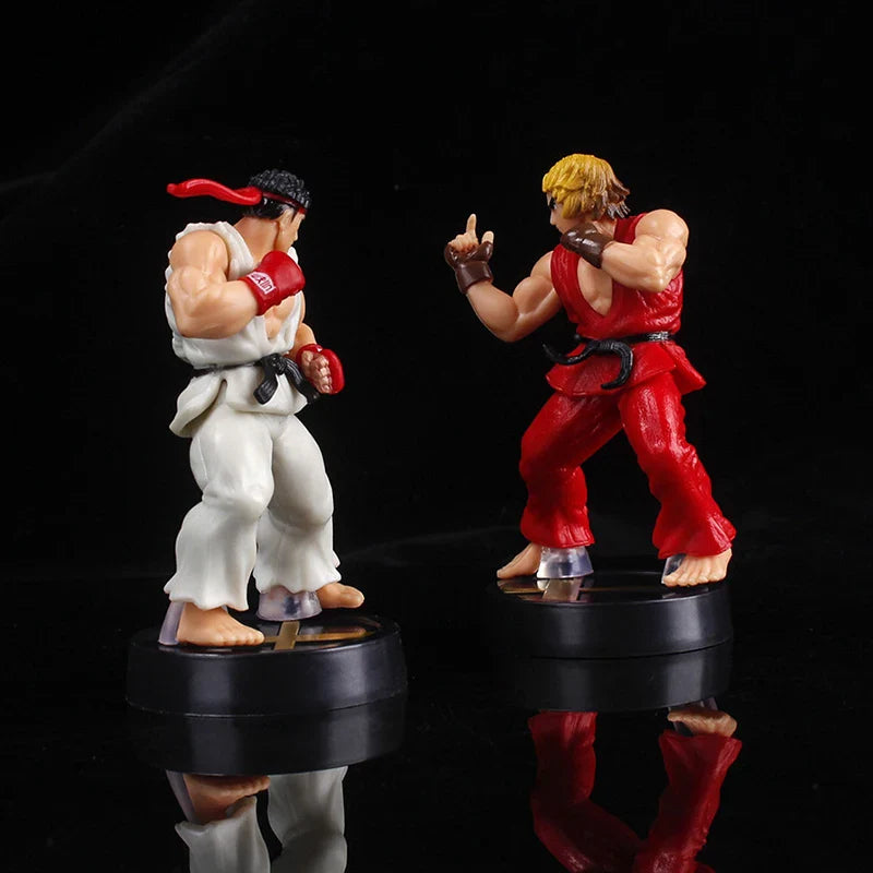 Two action figure statues on black bases against a black background.