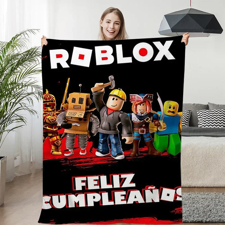 Person holding a Roblox-themed birthday blanket with characters and text in a living room.