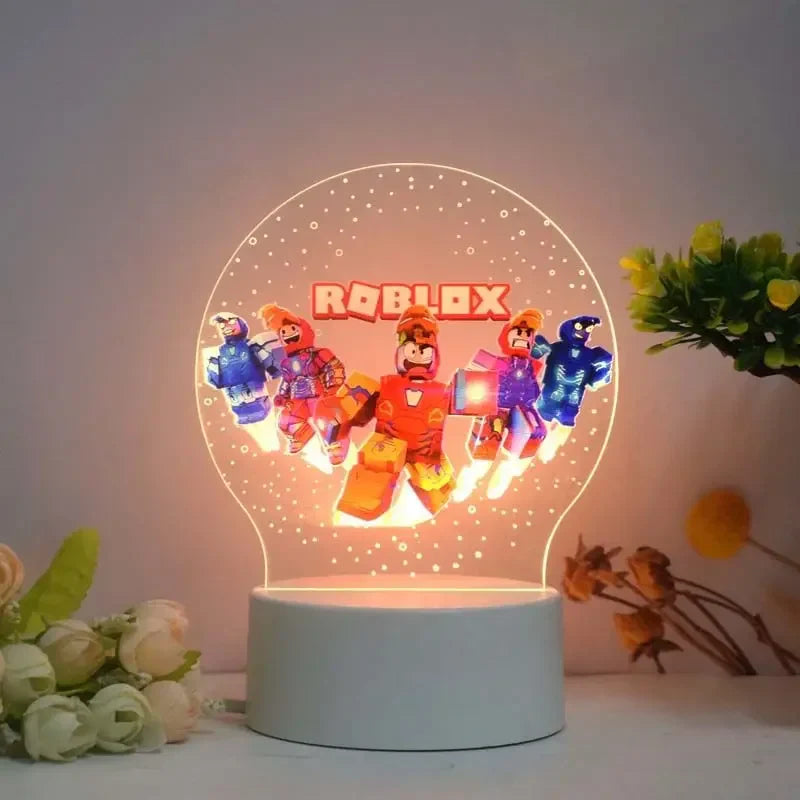 Roblox-themed night light with characters on a white base, surrounded by flowers and plants.