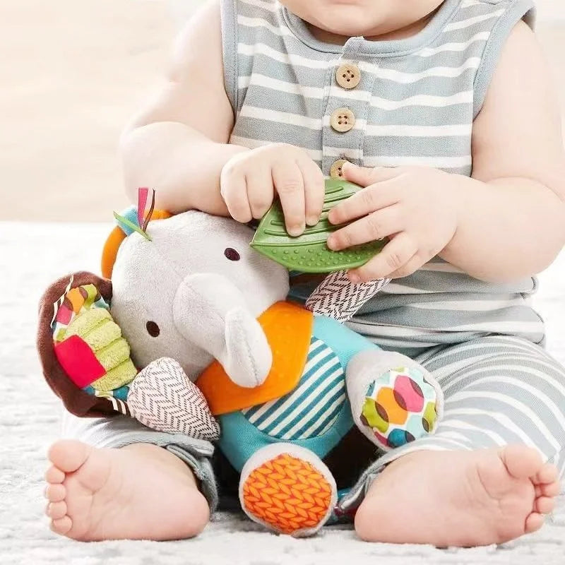 Baby playing with a colorful elephant toy on a light background.