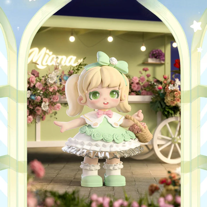 Toy figure of a girl in a green dress with a floral background.