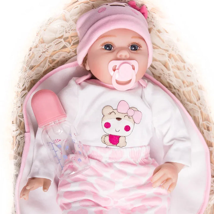 Baby doll with pink outfit, pacifier, and bottle on a textured surface.