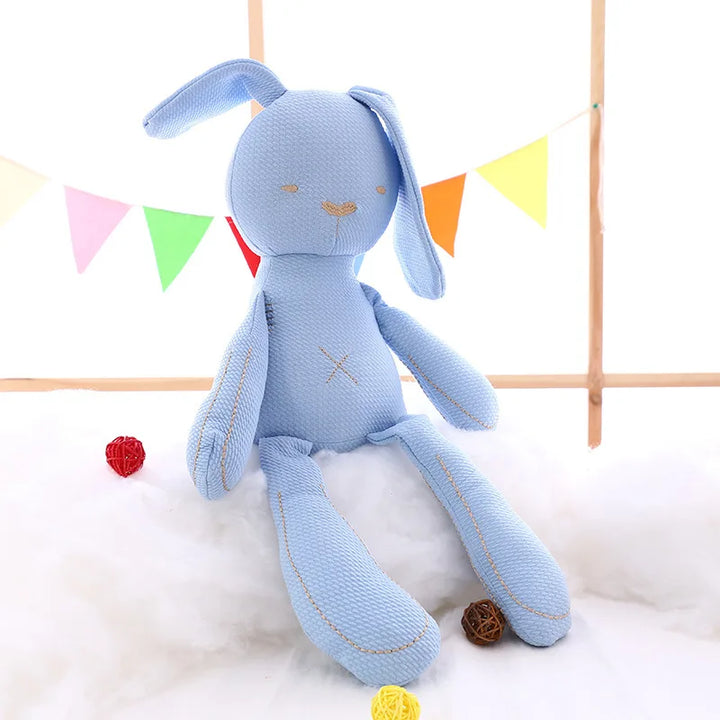 Blue stuffed bunny toy with colorful flags in the background.