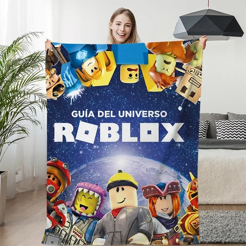 Person holding a Roblox-themed blanket with characters and text in a living room.