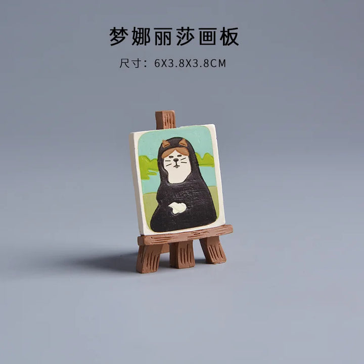 Small wooden easel with a miniature painting on a gray background.