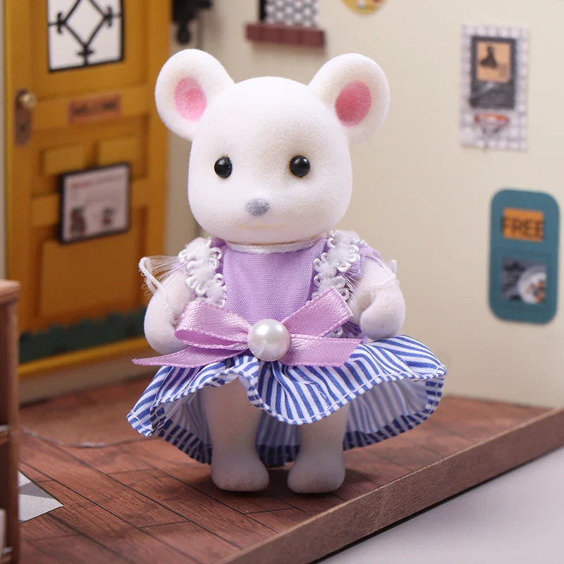 White teddy bear toy in a purple and blue dress standing on a wooden surface.