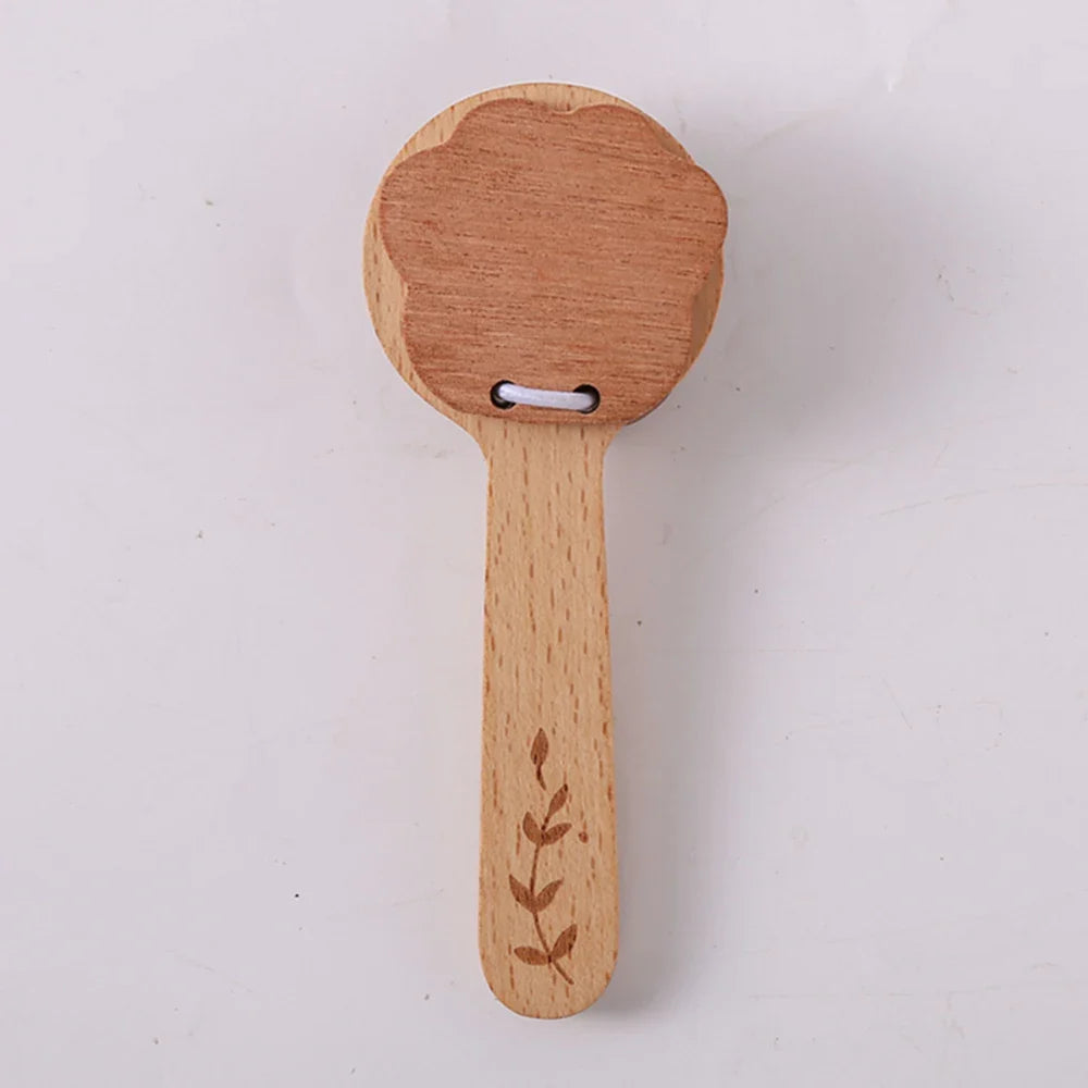 Wooden paddle with floral design on a white background.