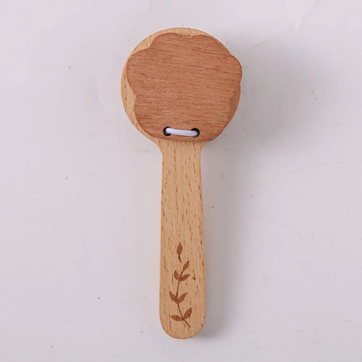 Wooden paddle with floral design on a white background.