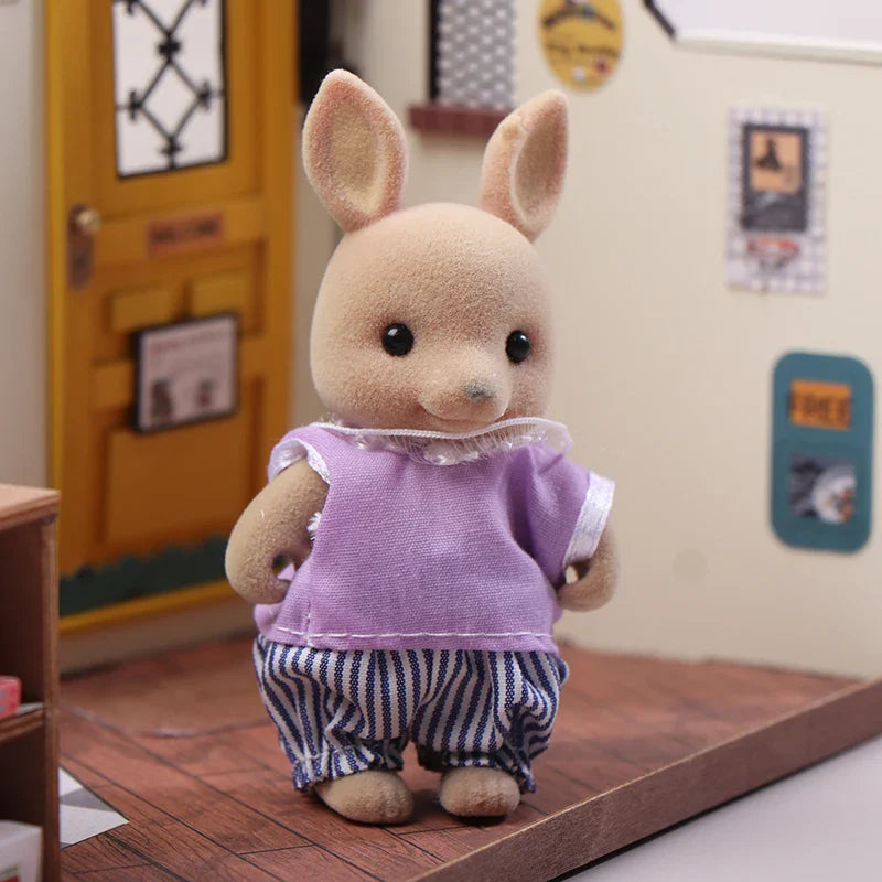 Stuffed animal toy in a room with a yellow door and framed pictures on the wall.