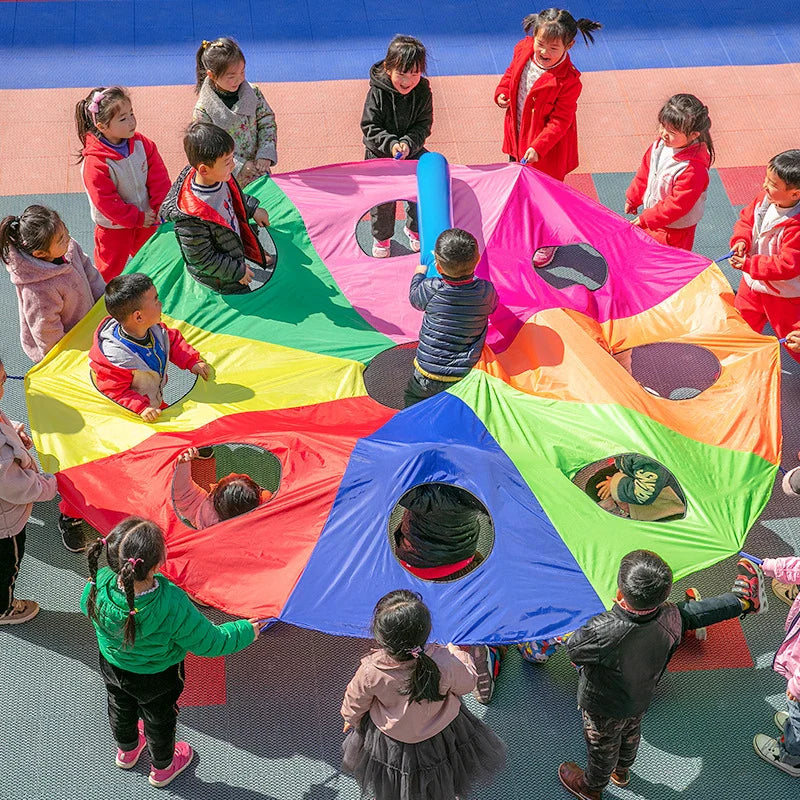 Children playing with a colorful parachute on a playground.