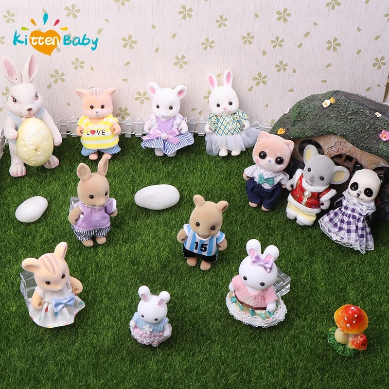 Collection of small animal figurines with a kitten baby brand logo on a grass-like surface.