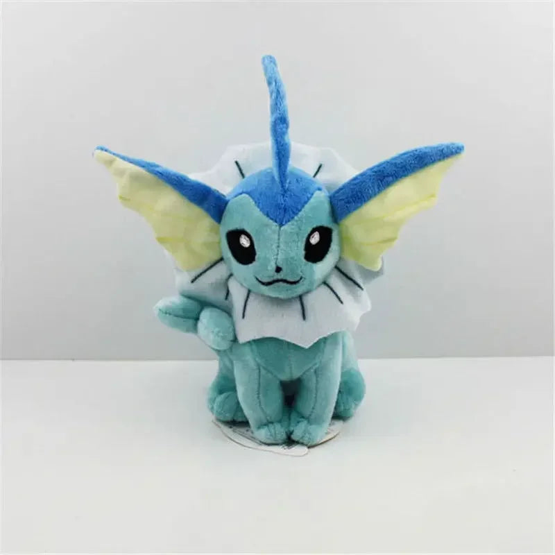 Plush toy of a blue and green creature with large ears on a white background.
