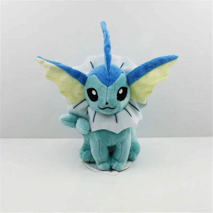 Plush toy of a blue and green creature with large ears on a white background.