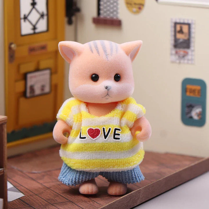 Plush toy cat wearing a yellow striped shirt with love on a wooden floor.
