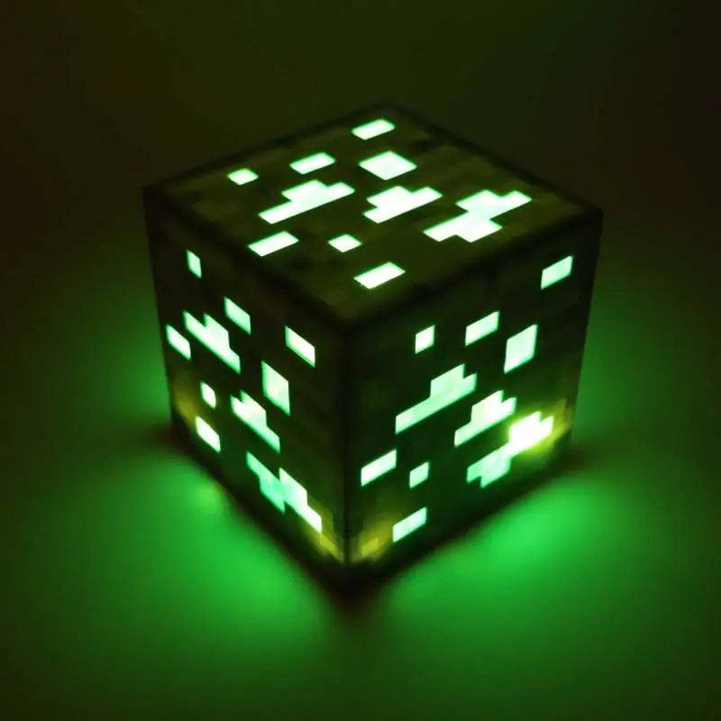 Cube-shaped light emitting a green glow on a dark background.