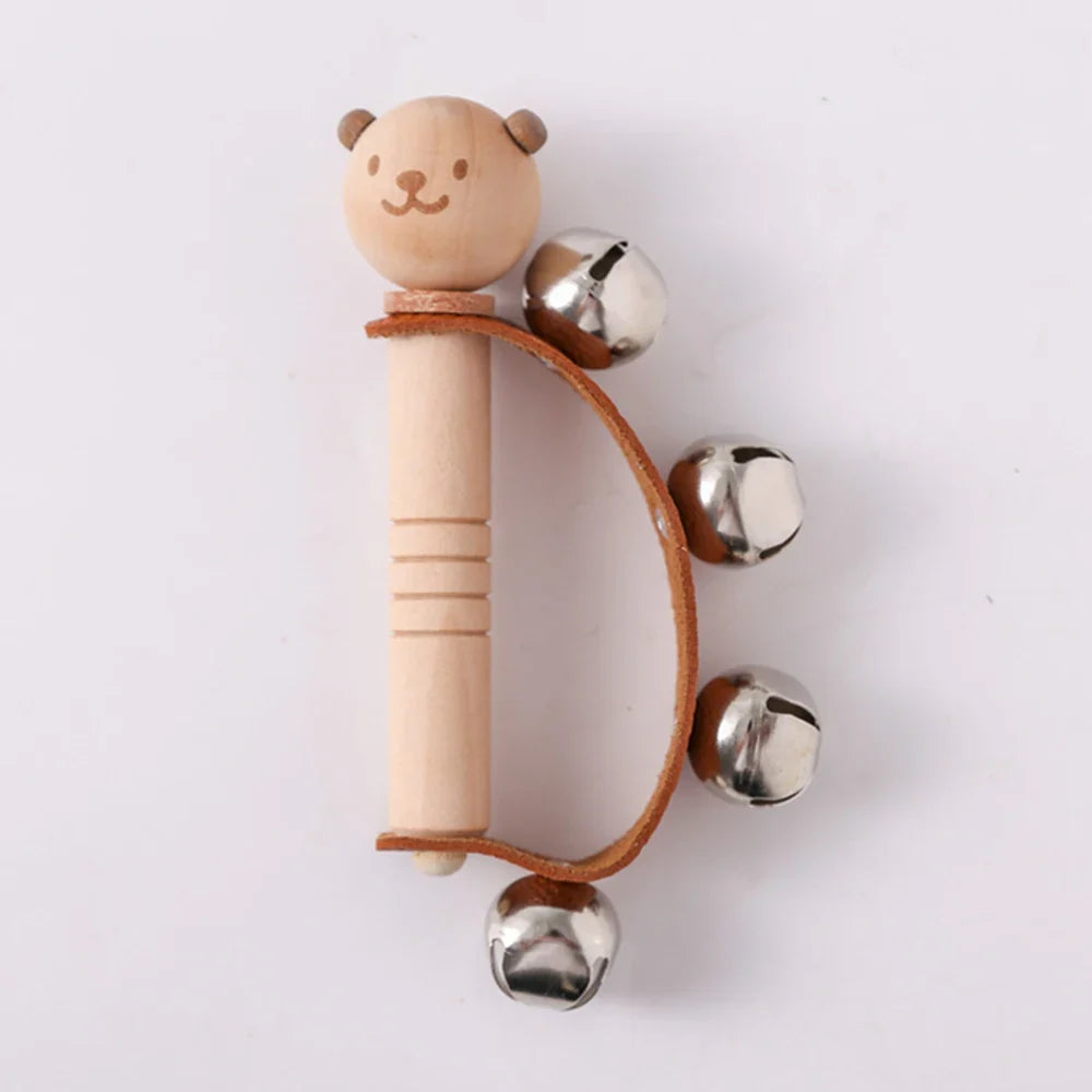 Wooden rattle with a bear face and metal bells on a white background.