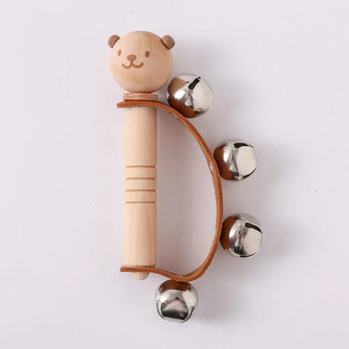 Wooden rattle with a bear face and metal bells on a white background.