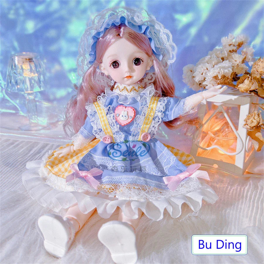 Doll in a blue dress with a heart design, sitting next to a lantern on a soft surface.