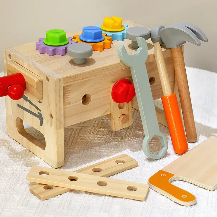 Toy tool set with wooden block and colorful tools on a light surface.