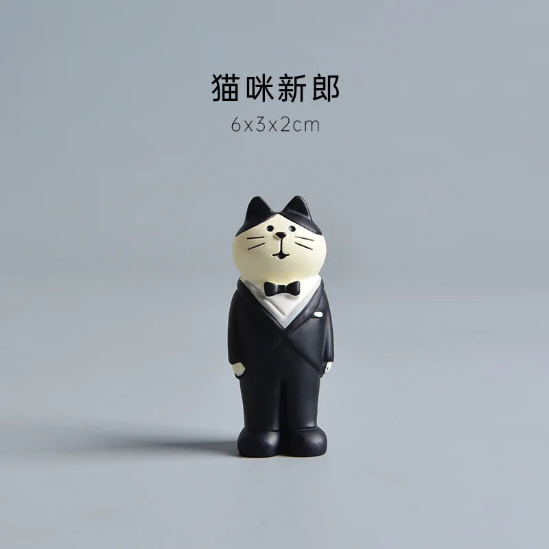 Cat figurine in a tuxedo on a gray background.
