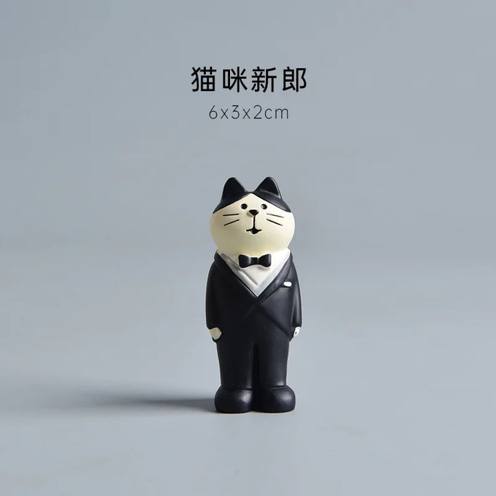 Cat figurine in a tuxedo on a gray background.