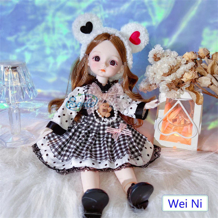 Doll with bear ears and checkered dress sitting on a soft surface with decorative elements.