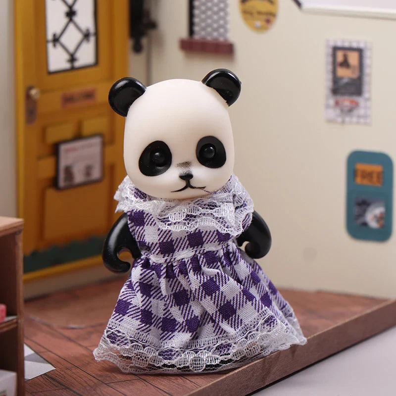 Panda toy wearing a purple checkered dress on a wooden surface.