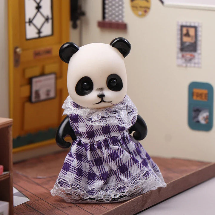 Panda toy wearing a purple checkered dress on a wooden surface.