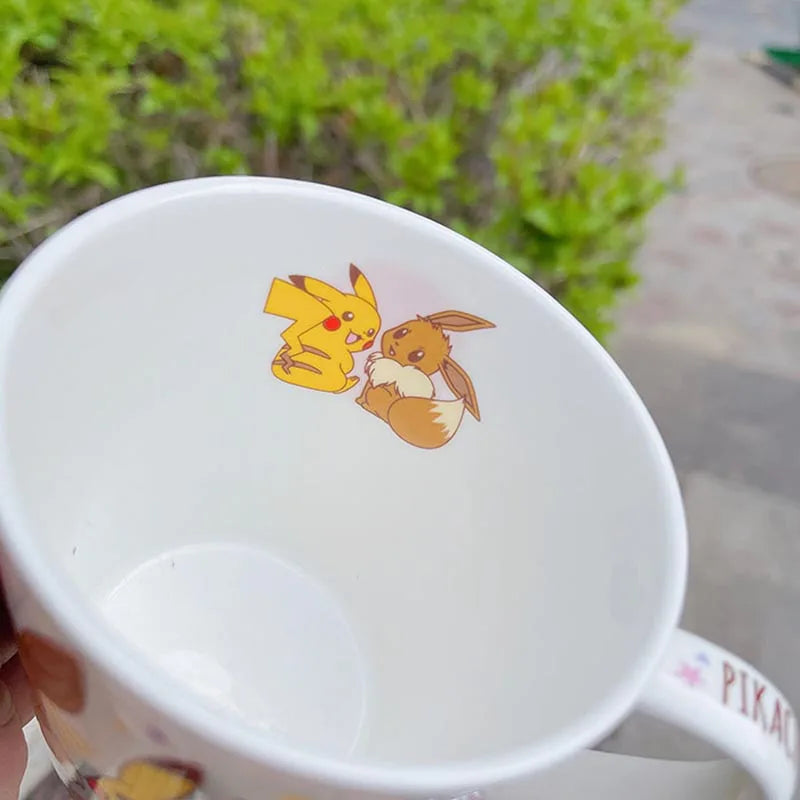 White mug with cartoon characters on a blurred green outdoor background.